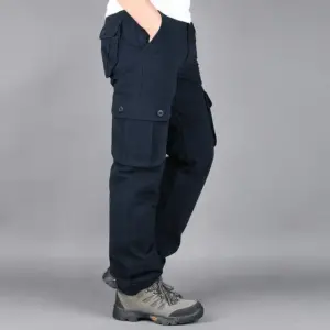 Person posing in Men's Military Tactical Pants Cotton Work Overalls Cargo Loose Straight Gym Running Training Sports Wear Jogger Sweatpants and hiking boots.
